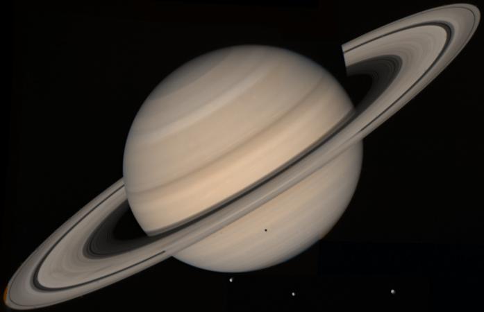La planète Saturne vue par Voyager 2. On voit aussi la présence des lunes Téthys et son ombre sur la planète, Dioné et Rhéa.