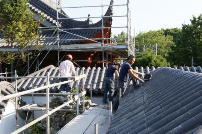 Réfection du Jardin de Chine - Été 2016 - Pose des tuiles sur les toits par les travailleurs chinois. Travaux de peinture.